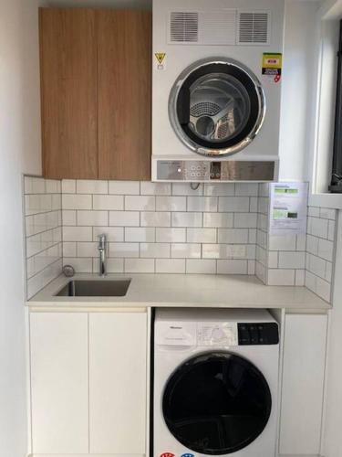 a kitchen with a washing machine and a sink at Rusty's Ridge in Jindabyne