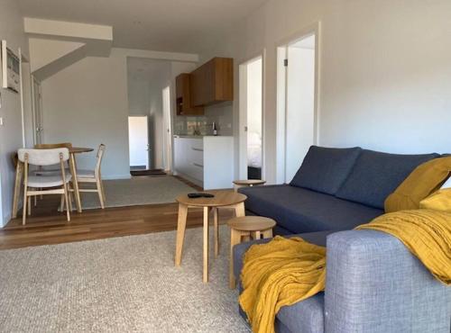 a living room with a blue couch and a kitchen at Rusty's Ridge in Jindabyne