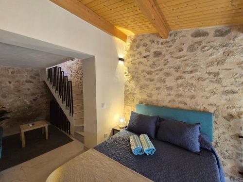 a bedroom with a bed and a stone wall at Grupo García de Paredes apartamentos turísticos in Trujillo
