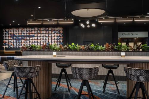 a lobby with two tables and chairs and plants at Glasgow Marriott Hotel in Glasgow