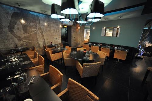 a dining room with tables and chairs in a restaurant at Nota Bene in Montceau-les-Mines