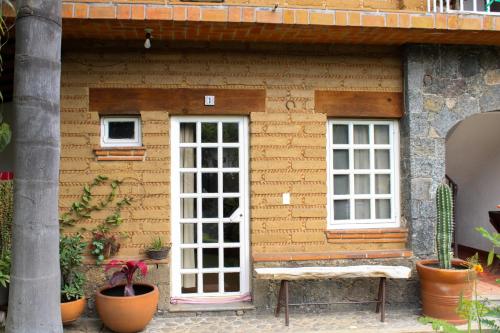 a building with two windows and a white door at Posada Guayacán Tepoztlán in Tepoztlán