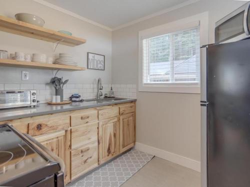 a kitchen with wooden cabinets and a stainless steel refrigerator at Mt Air Motel in Mount Hood Village