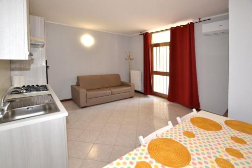 デセンツァーノ・デル・ガルダにあるAppartamento Capolaterraのキッチン(テーブル、ソファ付)