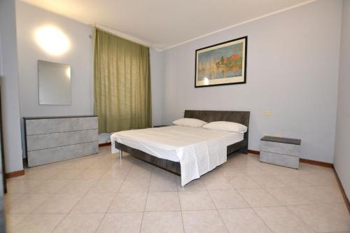 a bedroom with a white bed and a mirror at Appartamento Capolaterra in Desenzano del Garda