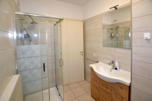 デセンツァーノ・デル・ガルダにあるAppartamento Capolaterraの洗面台とシャワー付きのバスルーム