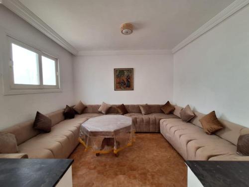 a living room with a large couch and a table at Superbe Villa Avec Piscine & Belle Vue Sur Mer in Tamaris