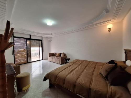 a bedroom with a bed and a couch in it at Superbe Villa Avec Piscine & Belle Vue Sur Mer in Tamaris