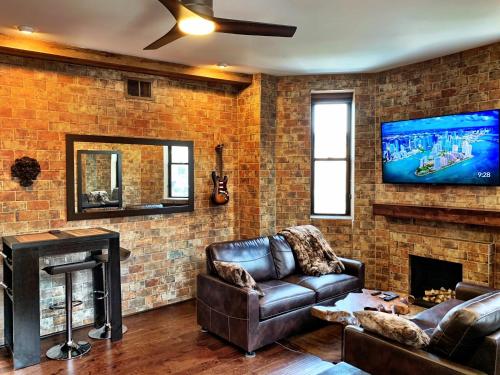 a living room with a leather couch and a fireplace at The Picasso on Lincoln Park in Chicago