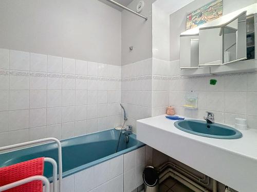 une salle de bain avec un lavabo et une baignoire dans l'établissement Appartement central avec balcon, parking privé - FR-1-361-66, à Granville