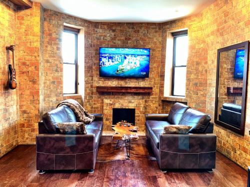 a living room with two leather chairs and a fireplace at The Picasso on Lincoln Park in Chicago
