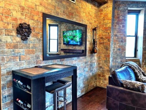 a room with a table with a tv on a brick wall at The Picasso on Lincoln Park in Chicago