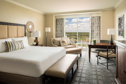 ein Hotelzimmer mit großem Bett und Schreibtisch in der Unterkunft The Ritz-Carlton Naples, Tiburon in Naples