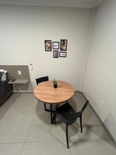 a table and chairs in a room with pictures on the wall at Prédio San Paolo - Bairro Santa Mônica próximo a UFU / Prefeitura / Center Shopping in Uberlândia