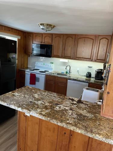 a kitchen with wooden cabinets and a granite counter top at Well Maintained First Floor Duplex Close To The Ocean And Bay Beach In Harvey Cedars in Harvey Cedars