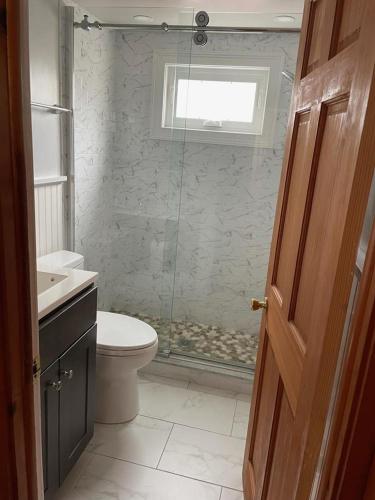a bathroom with a shower and a toilet and a sink at Well Maintained First Floor Duplex Close To The Ocean And Bay Beach In Harvey Cedars in Harvey Cedars