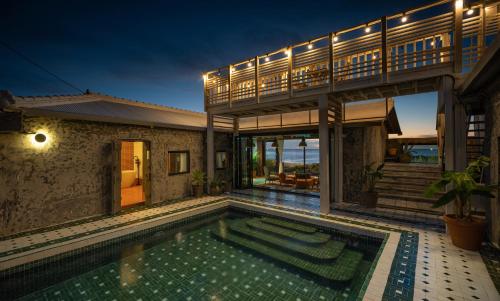 a house with a swimming pool in front of a house at Ocean View Riad Jeju in Jeju