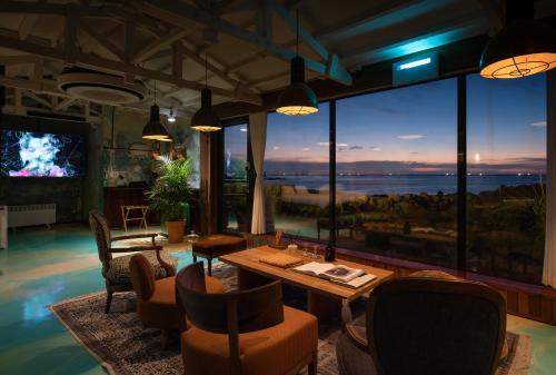 a living room with a table and chairs and a television at Ocean View Riad Jeju in Jeju