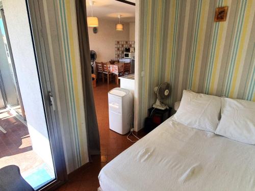 Cet appartement comprend une chambre avec un lit et une chambre avec une cuisine. dans l'établissement Appartement 2 pièces avec parking et wifi, centre-ville Sainte-Maxime - FR-1-780-69, à Sainte-Maxime