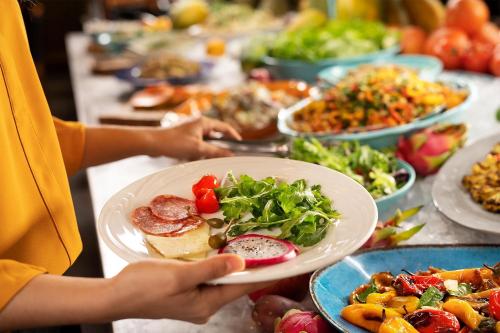 a person holding a plate of food at a buffet at The Westin Copley Place, Boston in Boston