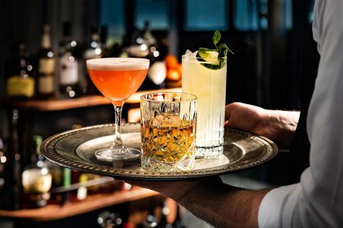 a person holding a tray with two drinks on it at The Westin Copley Place, Boston in Boston
