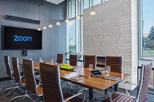 a conference room with a table and chairs and a screen at SpringHill Suites by Marriott Denver Downtown in Denver
