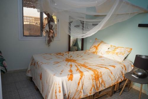 a bedroom with a bed with an orange and white comforter at appartement cosy in Somone
