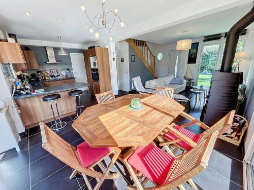 une cuisine et une salle à manger avec une table et des chaises en bois dans l'établissement Maison calme, proche tennis, 3 chambres, terrasse, Wi-Fi, parking - FR-1-361-554, à Jullouville
