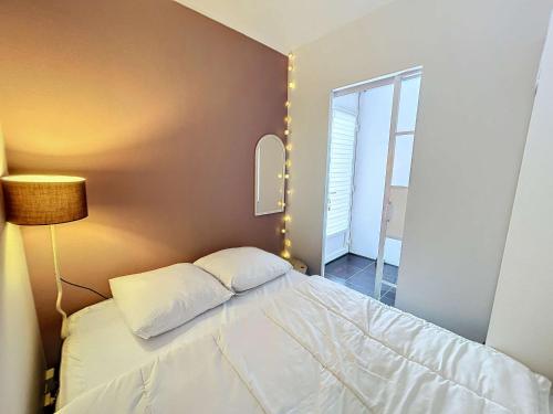 - une petite chambre avec un lit et une lampe dans l'établissement Appartement RDC près de la plage avec terrasse et Wi-Fi - FR-1-361-555, à Jullouville