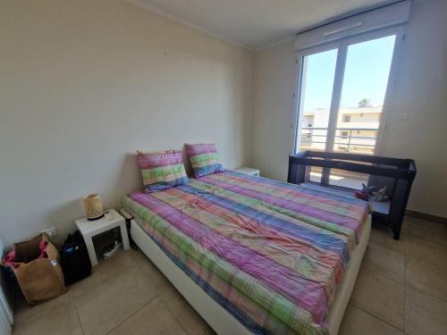 une chambre avec un lit et une grande fenêtre dans l'établissement Charmant appart climatisé 2 chambres avec terrasse et cuisine équipée - FR-1-100-344, à Cavalaire-sur-Mer