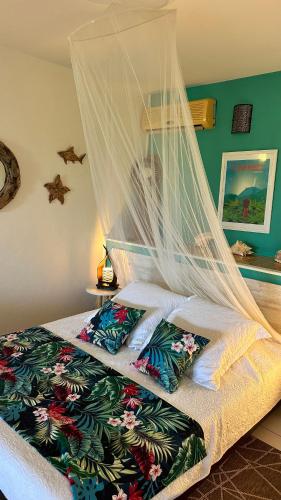 a bedroom with a bed with a mosquito net at Résidence Cocody in Sainte-Anne