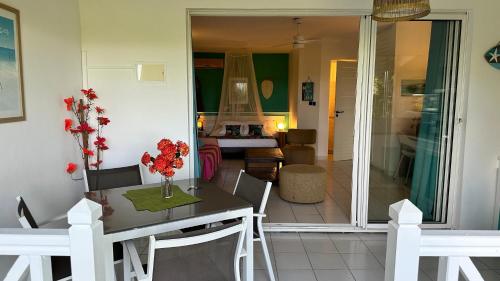 a dining room and living room with a table and chairs at Résidence Cocody in Sainte-Anne