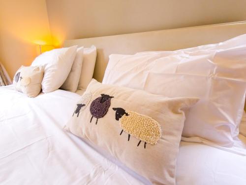 a bed with two pillows with sheep on it at The Bellhouse - hot tub lodge in Tomatin in Tomatin