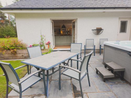 a picnic table and chairs on a patio at The Bellhouse - hot tub lodge in Tomatin in Tomatin