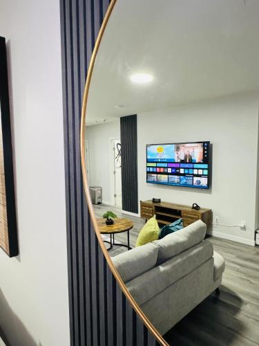 a living room with a couch and a mirror at The Glacier Royale - 1 Bed Suite in NW Calgary in Calgary