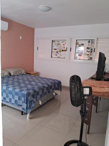 una camera da letto con un letto e una scrivania con un computer di Smilesurf room a Rio de Janeiro