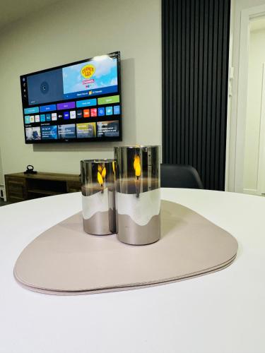 two candles sitting on a table in front of a tv at The Glacier Royale - 1 Bed Suite in NW Calgary in Calgary