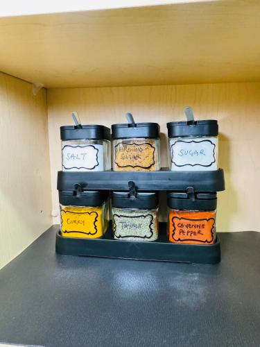 a shelf with four jars of food on it at The Glacier Royale - 1 Bed Suite in NW Calgary in Calgary