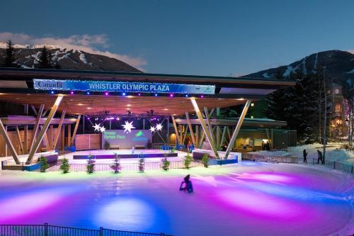 an ice skating rink at a ski resort at night at 2BR 2BA Whistler Escape with Newly Renovated Hot Tub, Steps from Olympic Rings and Cafes in Whistler