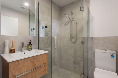 a bathroom with a shower and a sink and a toilet at Quirky New Stylish Free Park in Linwood