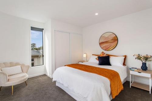 a white bedroom with a large bed and a chair at Quirky New Stylish Free Park in Linwood