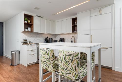 a kitchen with white cabinets and a white counter top at Luxury 2BR BackBay Boston Common T-station Roof Top Lounge Gym in Boston