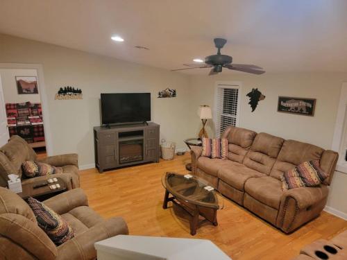 a living room with couches and a flat screen tv at The Perfect Porch Retreat in Eufaula