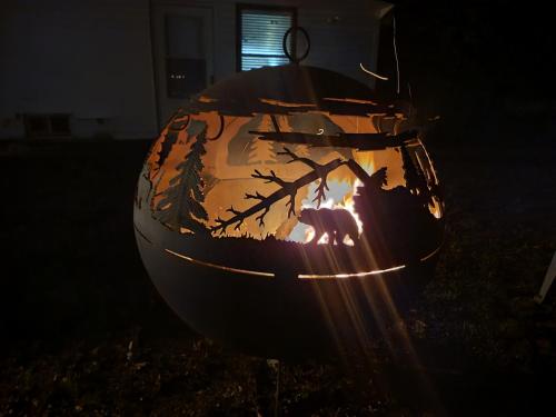 a large metal bowl with a fire in the dark at The Perfect Porch Retreat in Eufaula