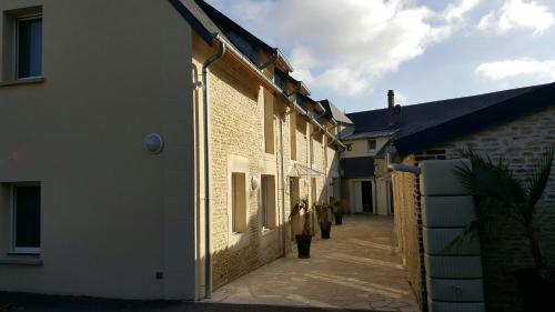 Una donna in piedi in un vicolo tra due edifici di Hotel de la Gare a Mézidon-Canon