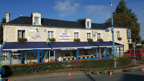 Un edificio con un tendone blu davanti di Hotel de la Gare a Mézidon-Canon