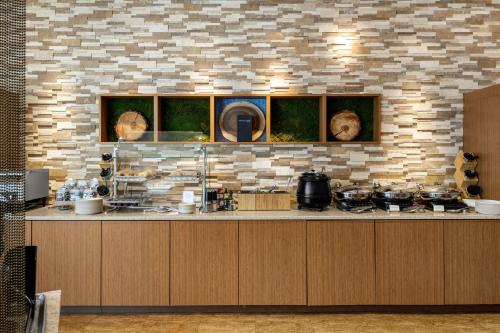 a kitchen with wooden cabinets and a brick wall at SpringHill Suites Coeur d'Alene in Coeur d'Alene