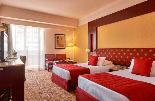 a hotel room with two beds and a television at Safir Hotel Cairo in Cairo