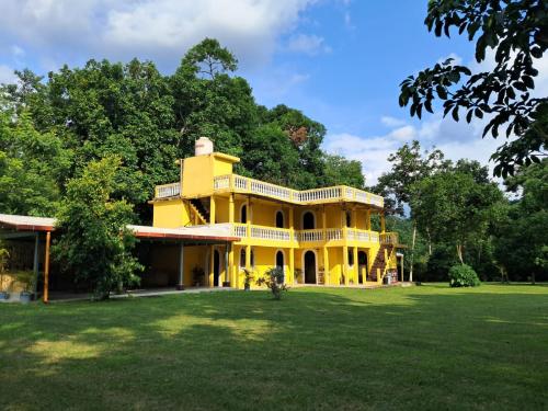 une grande maison jaune avec une grande cour dans l'établissement Hotel Posada San Jose, à Malacatán