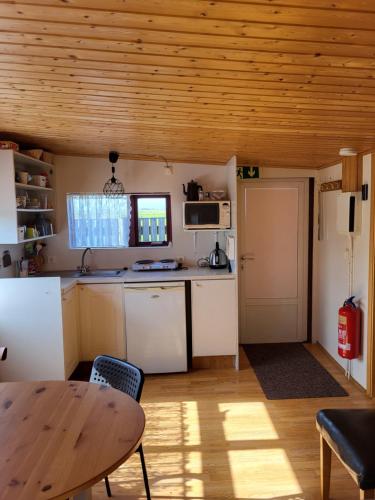 cocina con mesa y techo de madera en Vonarland hús með einu svefnherbergi, en Stokkseyri
